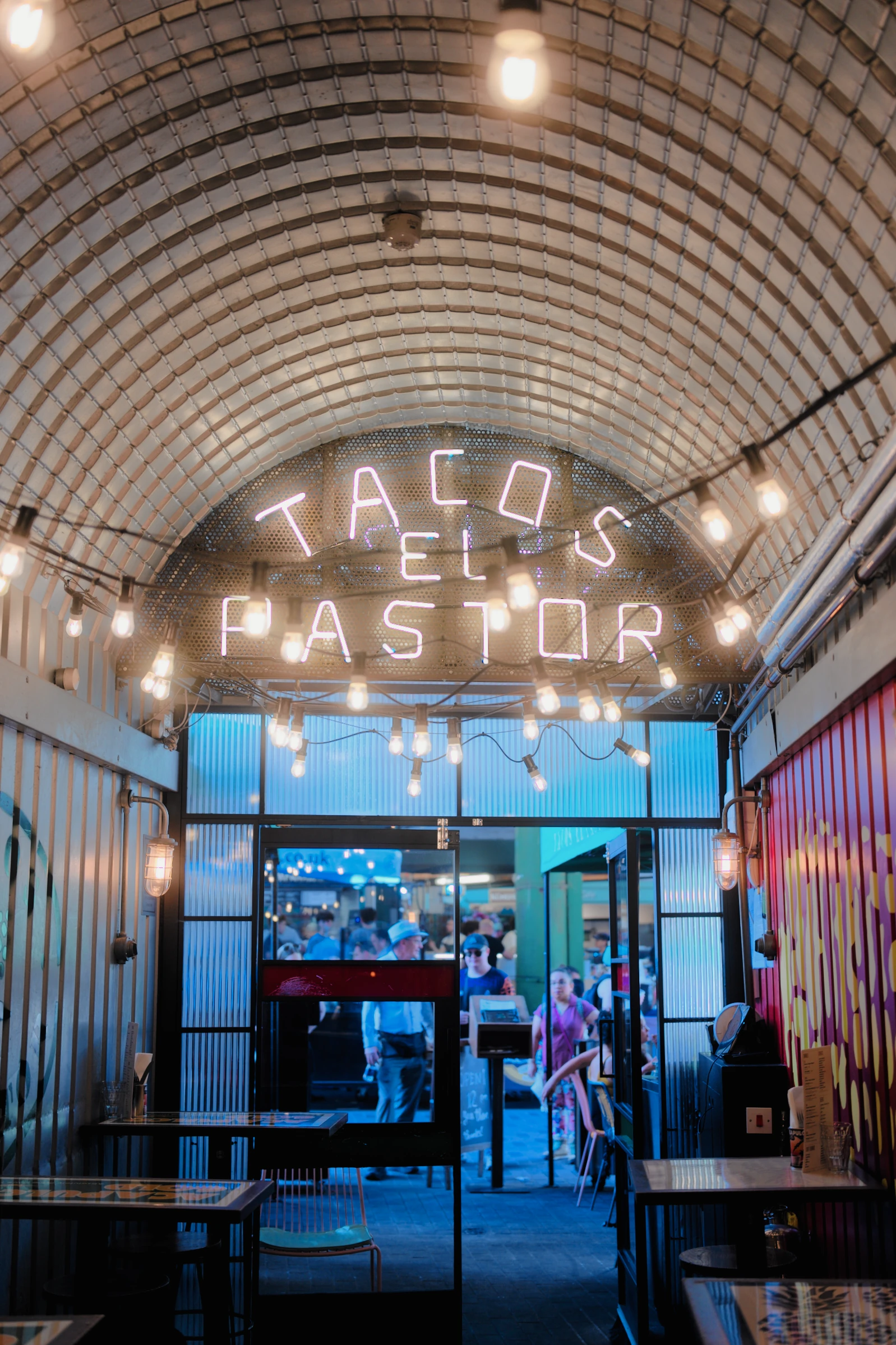 Illuminated restaurant lettering, warm tile and a cool doorway, rendered with the Kodak VISION3 500T film profile